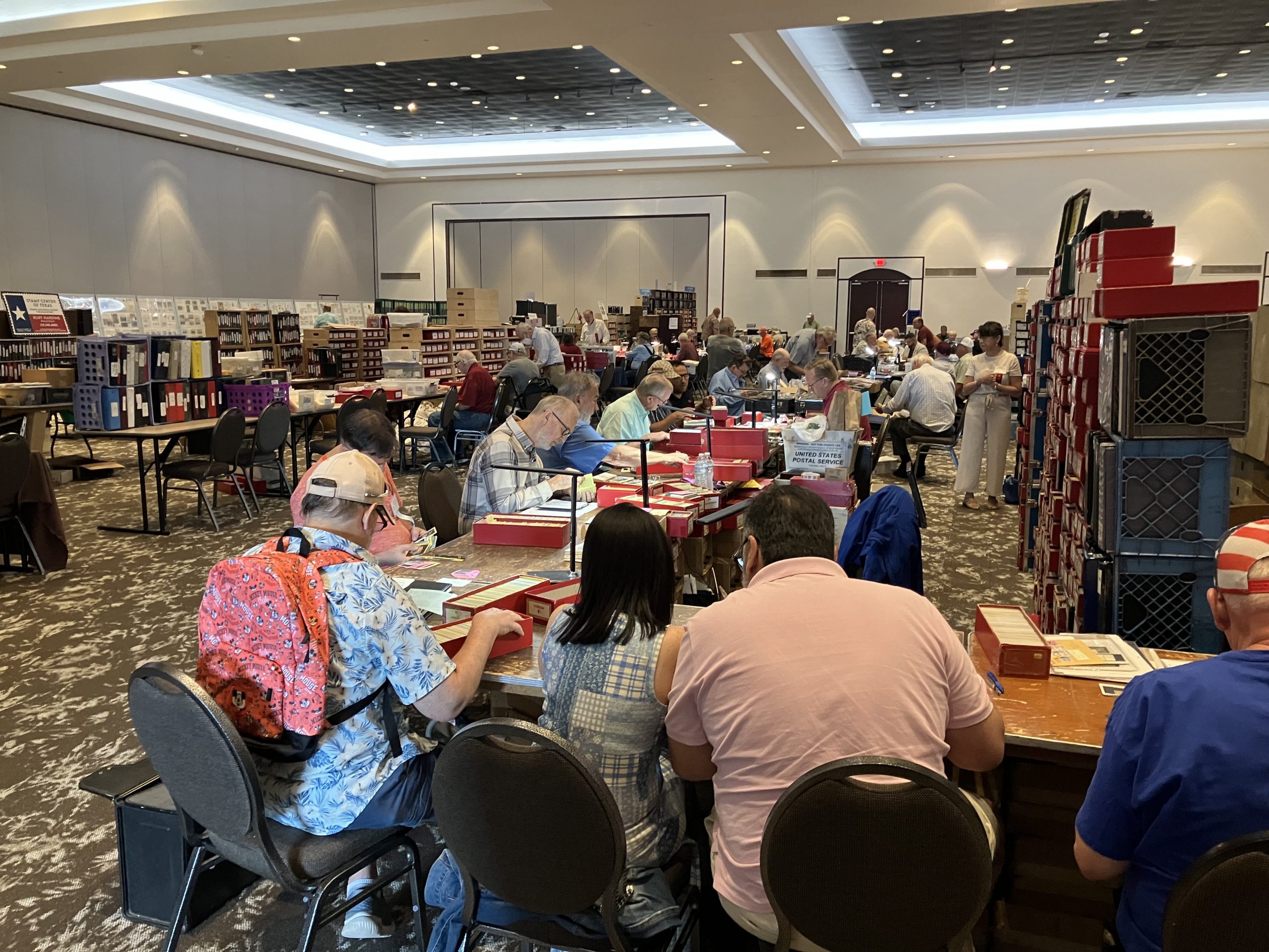 A to Z Stamps booth with collectors filling their available chairs.